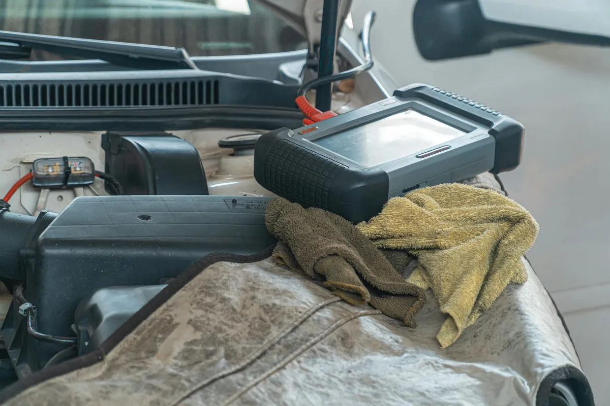 A mechanic inspecting a used car